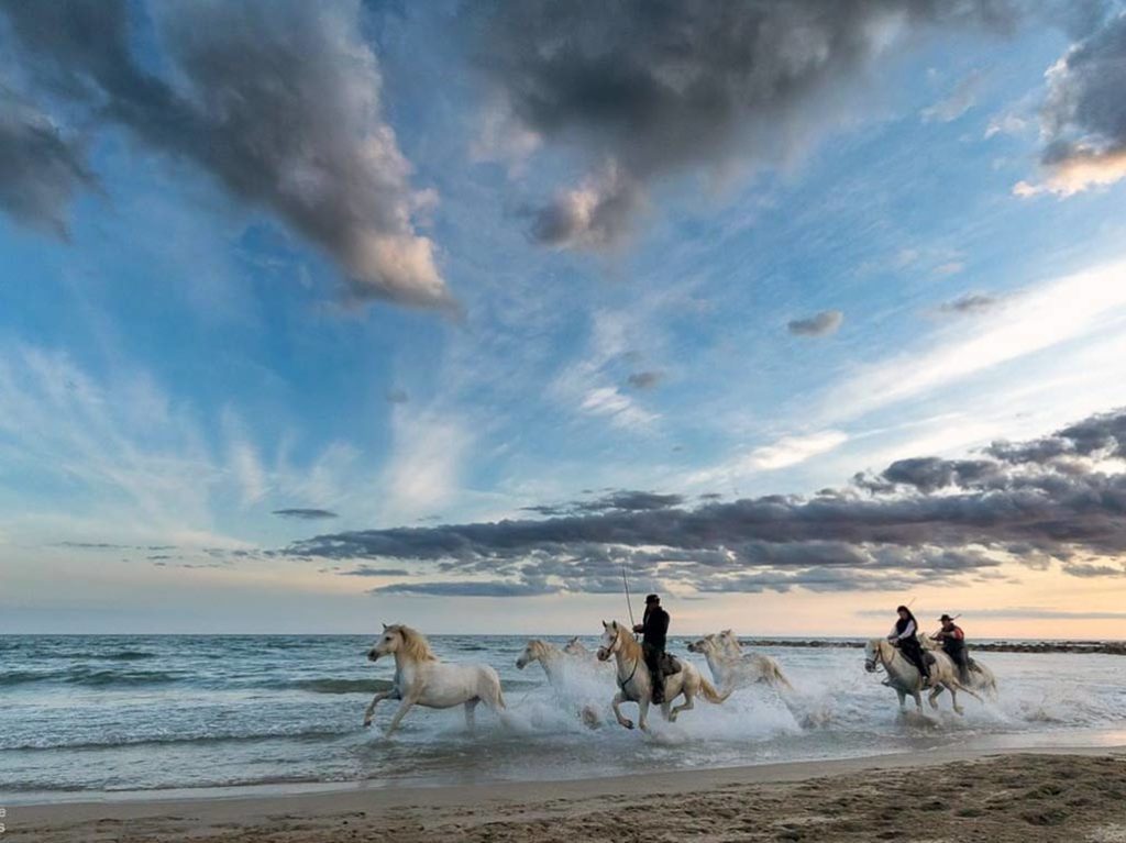 Gitanes auf Pferden am Strand